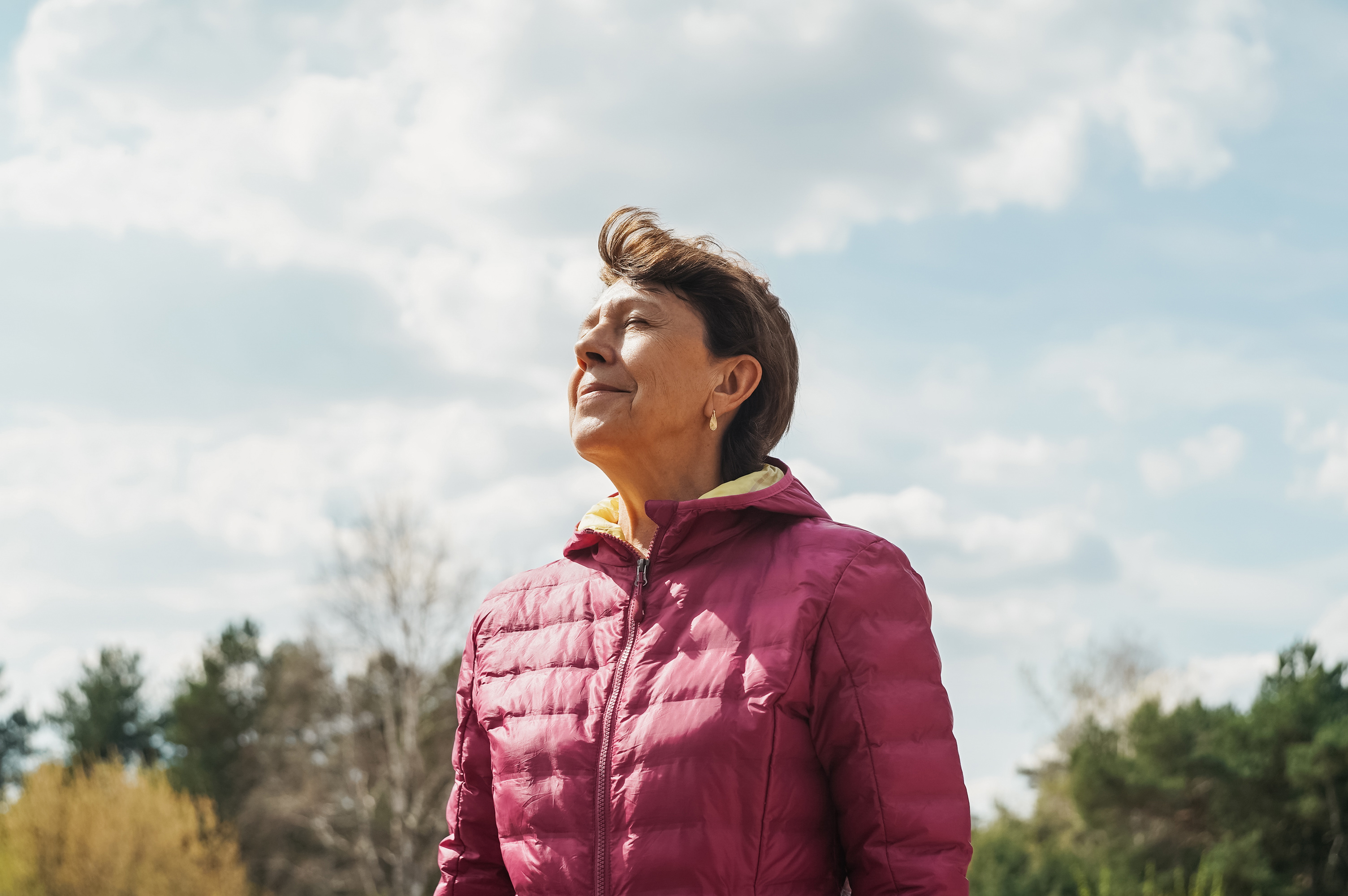 Senior woman portrait in nature. Woman breathe freely and enjoy life.