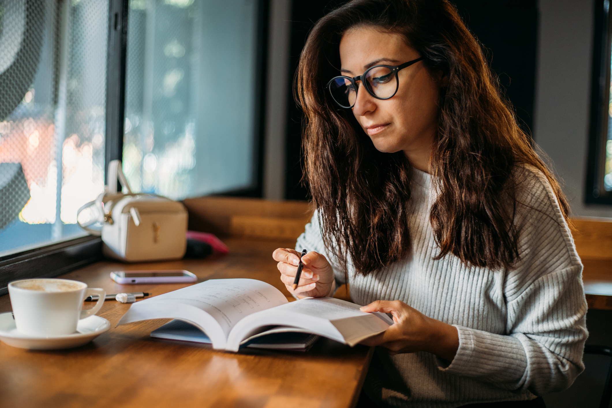 Female student taking notes at cafe