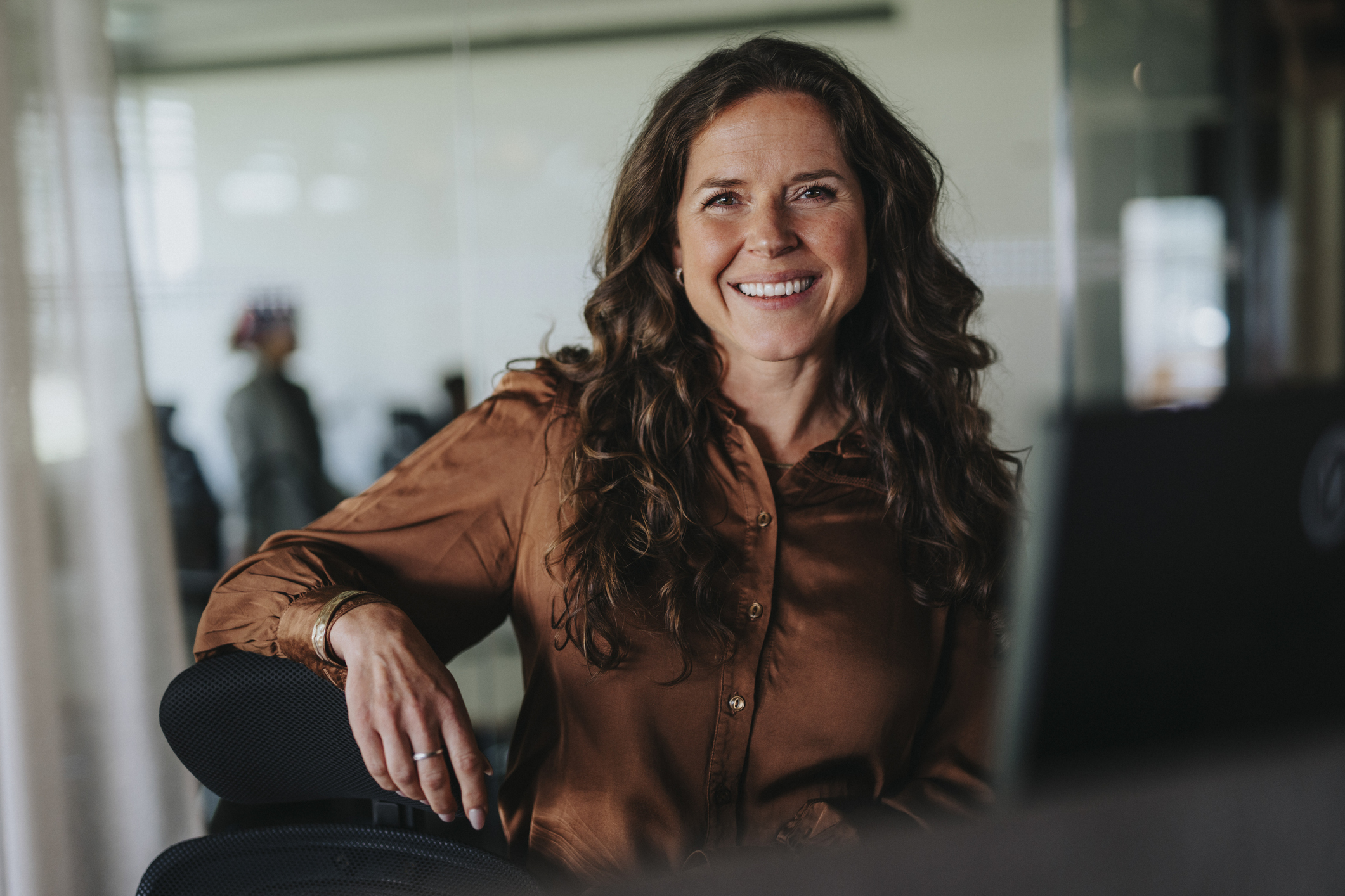 Portrait of happy mature businesswoman with brown hair in office