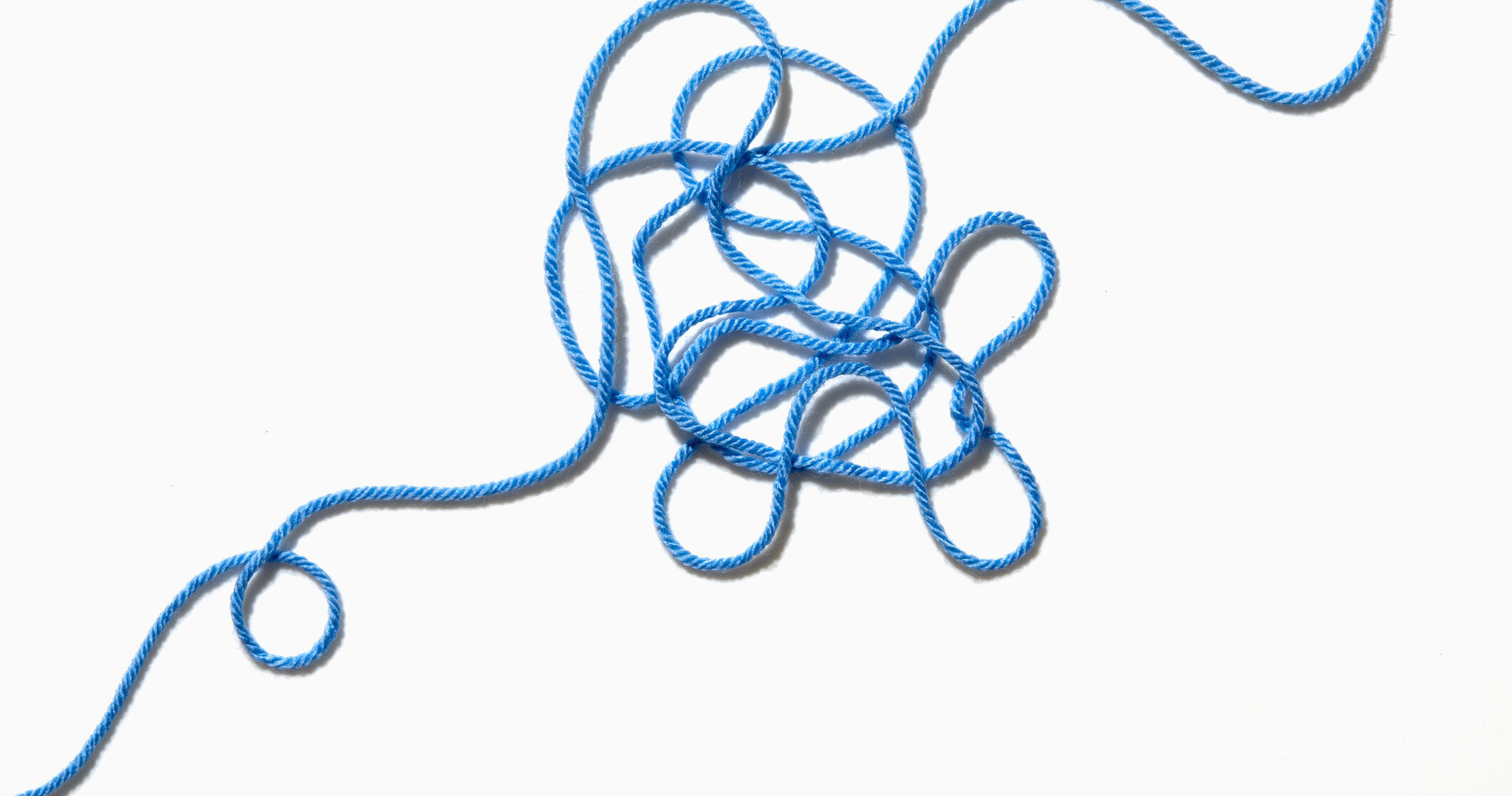Tangled blue yarn on white background