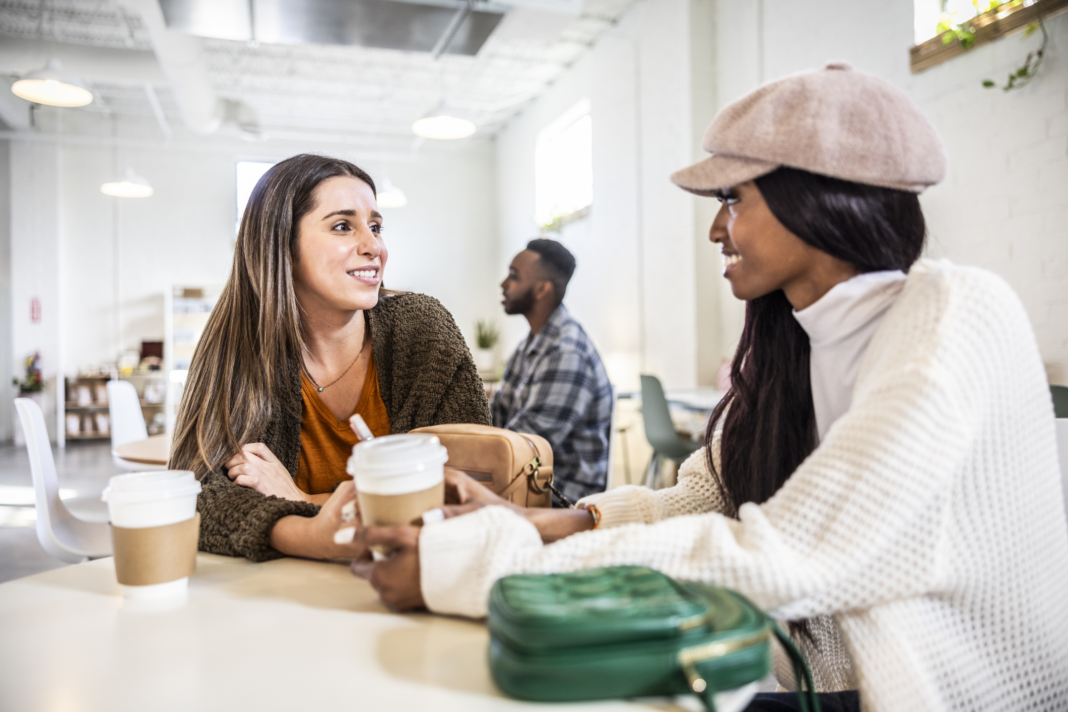 Young women hanging out and talking in modern coffeeshop